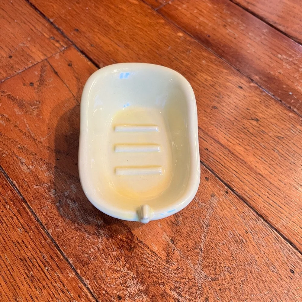 Vintage butter yellow ceramic soap dish shaped like bathtub.